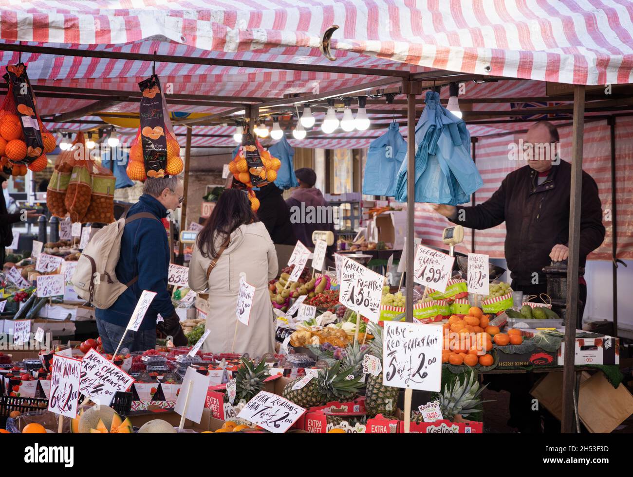 Marktstand Großbritannien; ein Lebensmittelgeschäft, das Obst und Gemüse von einem Marktstand, Saffron Walden Market, Saffron Walden Essex UK, verkauft Stockfoto