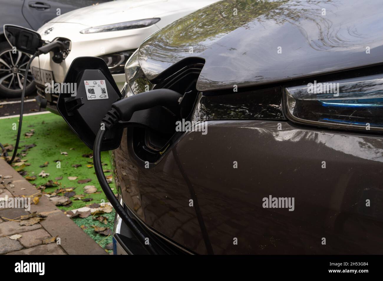 Porreres, Spanien; oktober 31 2021: Nahaufnahme eines dunklen Renault-Elektroautos an einer elektrischen Ladestelle, an der die Batterie geladen wird. Erneuerbare Energien Stockfoto