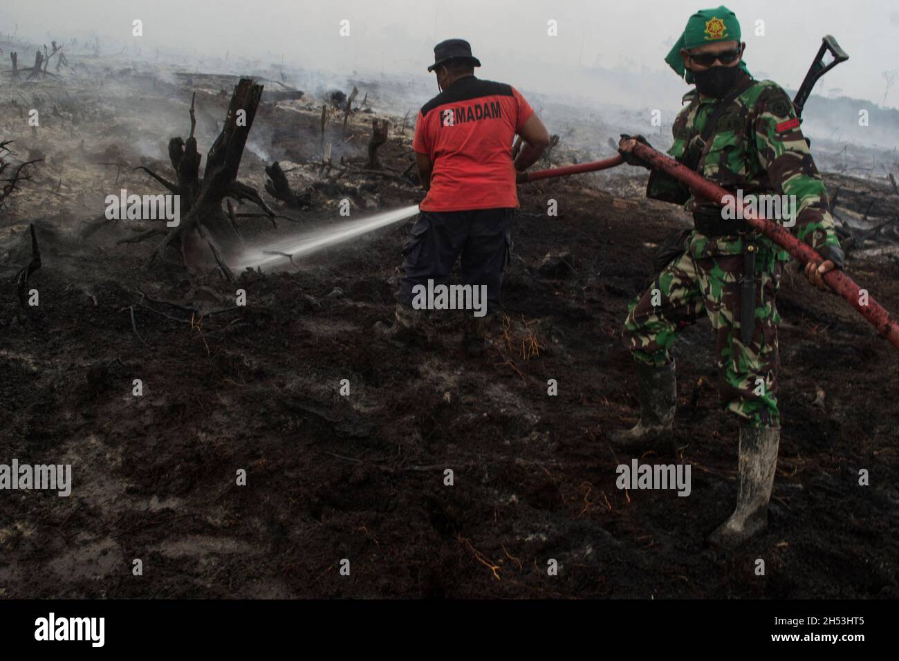 Bewaffnetes Militär- und Feuerwehrpersonal wird in einem Plantagengebiet in Riau, Insel Sumatra, Indonesien, gesehen, wie es Hotspots auslöscht. Fotografiert am 29. März 2014. Die COP26-Klimakonferenz in Glasgow leitet die Abkommen der Länder weltweit an, um die Treibhausgasemissionen zu reduzieren und den durchschnittlichen globalen Temperaturanstieg auf 1.5 Grad Celsius (34.7 Fahrenheit) zu halten. Und den Schutz der biologischen Vielfalt durch die Wiederherstellung des Waldverlustes und der Bodendegradation bis Ende des Jahres 2030 aus öffentlichen und privaten Mitteln. Foto von Aditya Sutanta/ABACAPRESS.COM Stockfoto