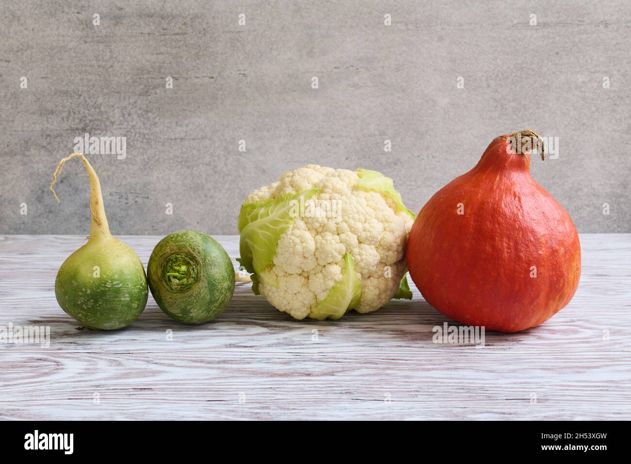 Gemüse Kürbis, Blumenkohl und grünes Rettich liegen auf einem Holztisch in einer Reihe Stockfoto