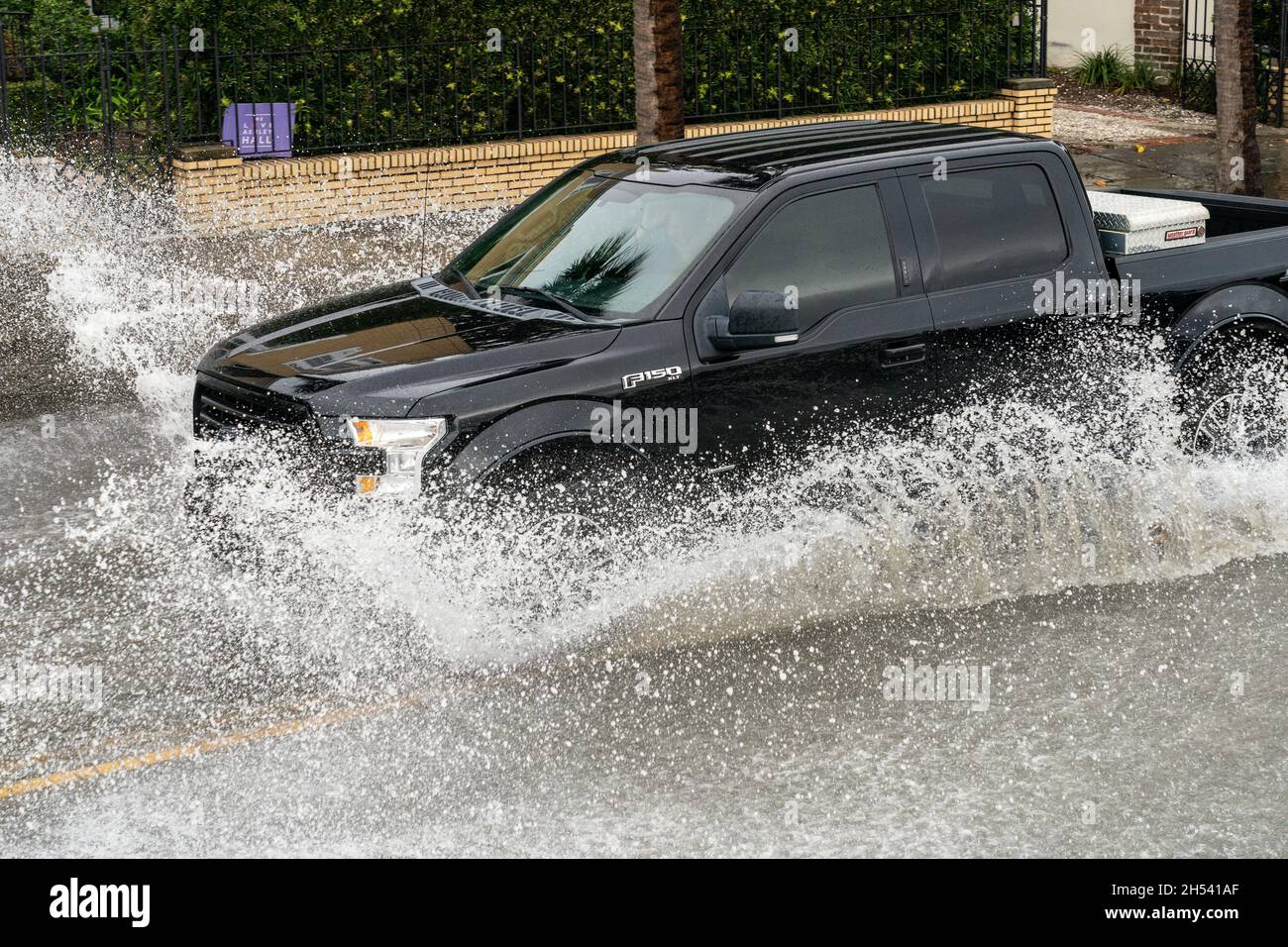 Charleston, Usa. November 2021. Ein Auto wird von Überschwemmungswasser entlang der East Battery Street umspült, nachdem der Rekord King Tides mit einem Offshore-Niederdruck-Trockensystem kombiniert wurde, das die historische Innenstadt am 6. November 2021 in Charleston, South Carolina, überschwemmt hat. Der Klimawandel und der Anstieg des Meeresspiegels haben die Überschwemmungen entlang der Küste von Charleston in den letzten zehn Jahren um fast das Zehnfache erhöht. Quelle: Richard Ellis/Richard Ellis/Alamy Live News Stockfoto