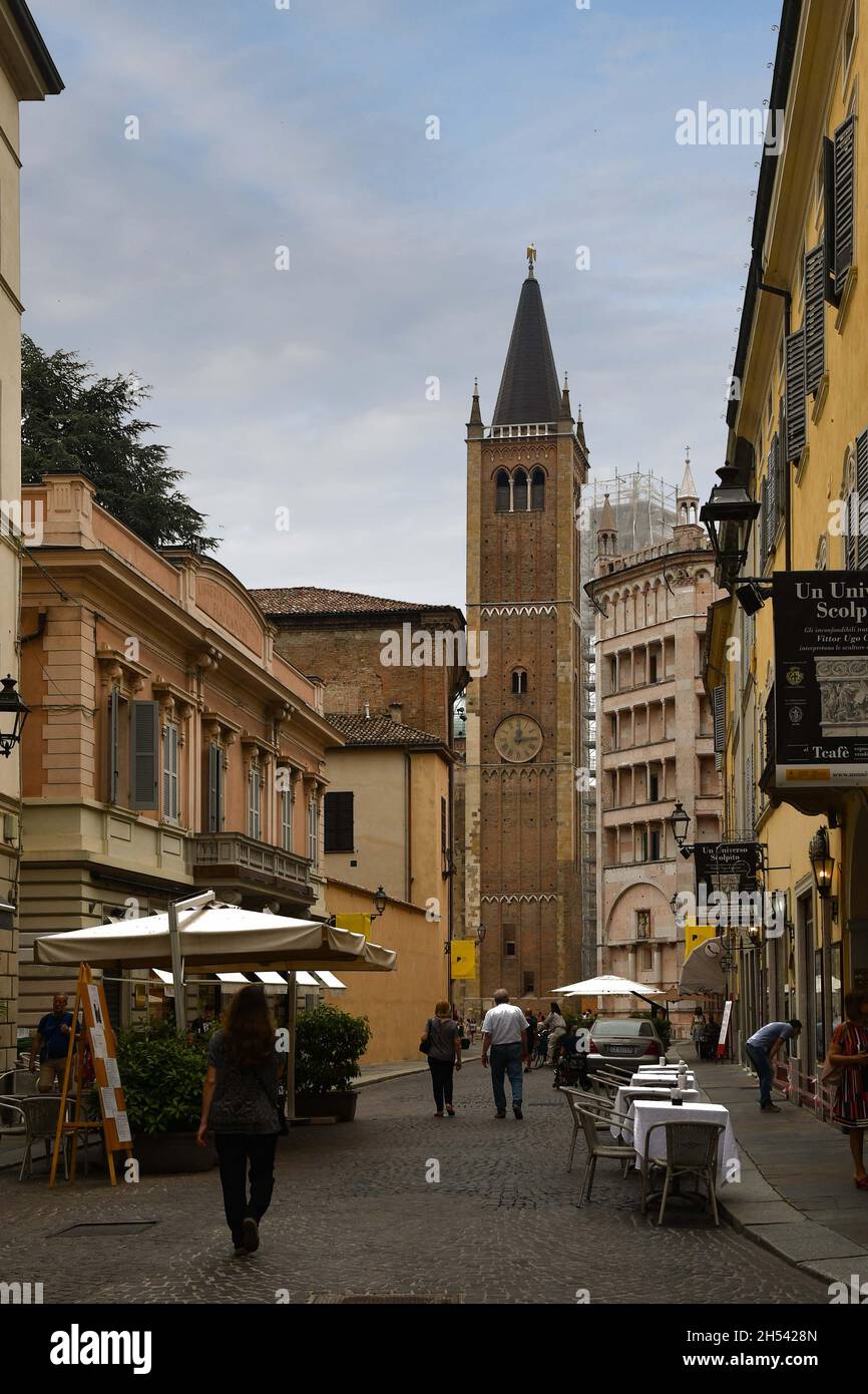 Blick auf die Straße des historischen Zentrums mit dem Glockenturm und dem Taufbecken der Kathedrale bei Sonnenuntergang, Parma, Emilia-Romagna, Italien Stockfoto