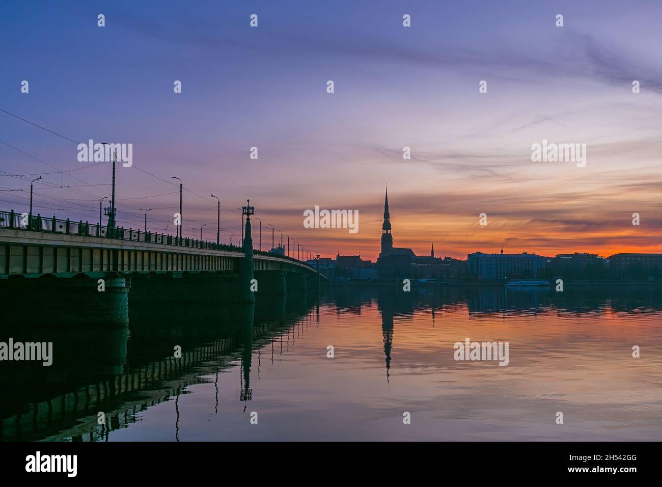 Der Sonnenaufgang über dem alten Riga spiegelte sich im Spiegel der Daugava wider Stockfoto