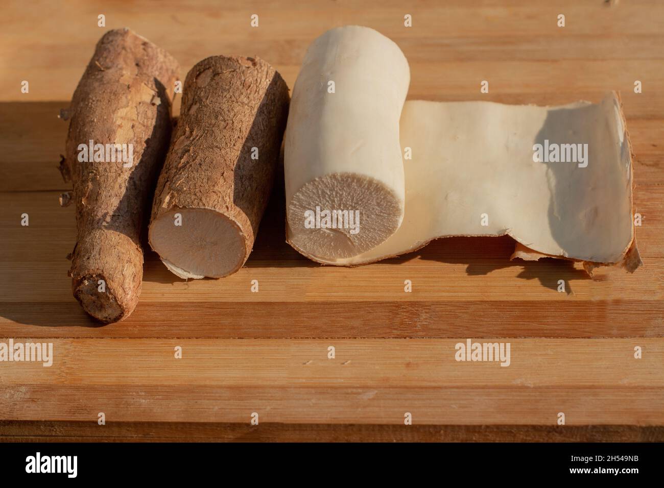 Cassava wird auf einem Kochbrett geschält Stockfoto