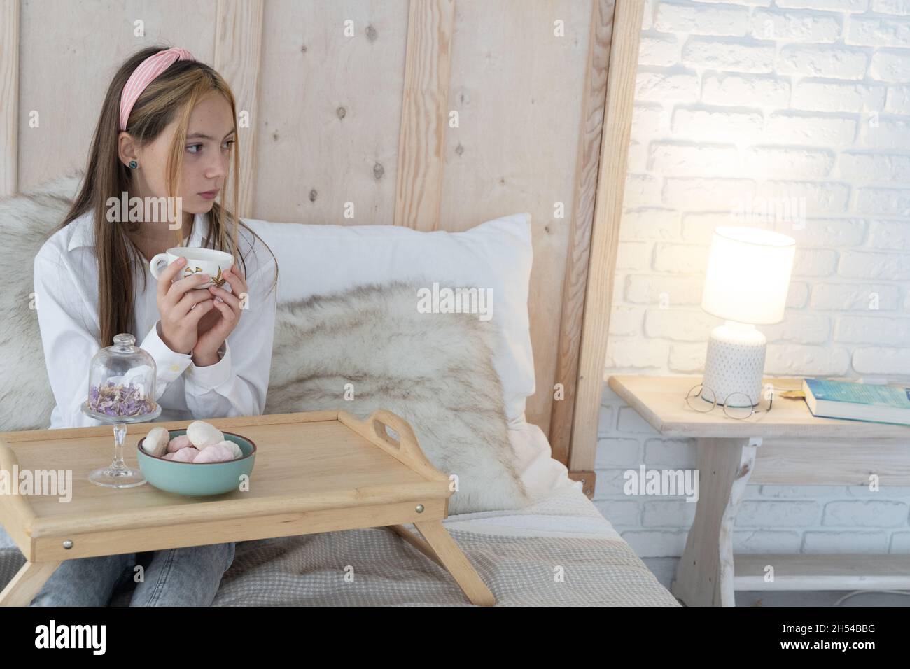 Schönes Mädchen mit einer Tasse Tee auf dem Sofa Stockfoto