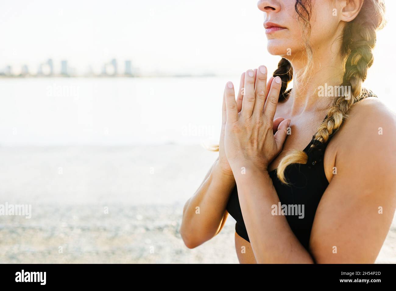 Frau meditiert in Sukhasana-Pose am Meer Stockfoto