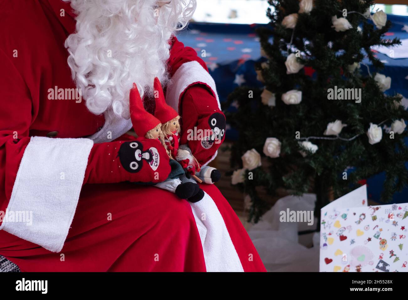 Weihnachtsmann mit Weihnachtsspielzeug, das für Kinder spielt. Weihnachtsstimmung und Weihnachtsunterhaltung für Kinder. Stockfoto