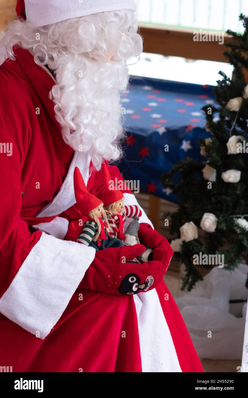 Weihnachtsmann mit Weihnachtsspielzeug, das für Kinder spielt. Weihnachtsstimmung und Weihnachtsunterhaltung für Kinder. Stockfoto