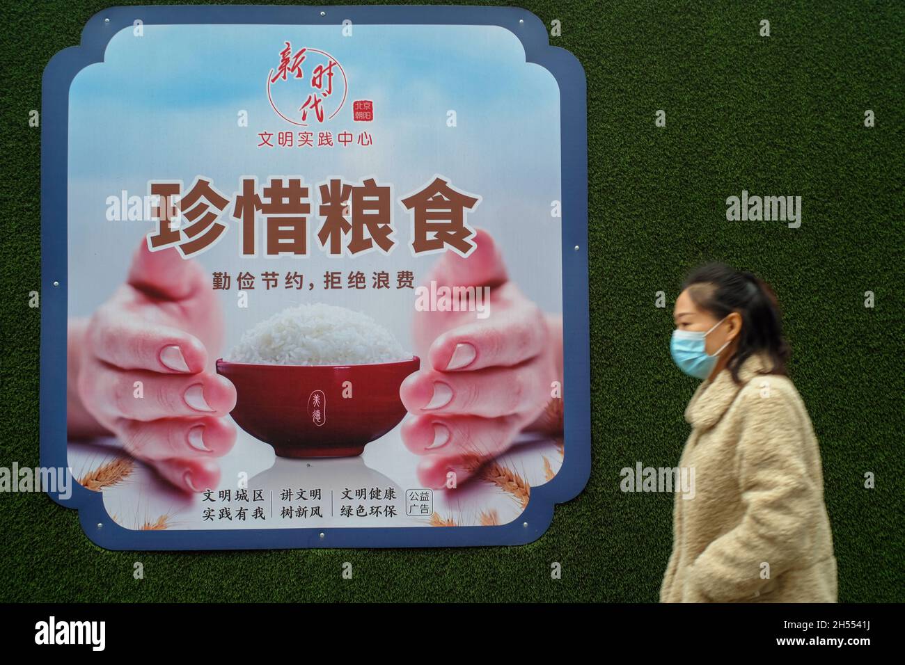 Eine Frau übergibt eine Plakatwand mit dem Thema „Essen schätzen“ in Peking, China. 06-Nov-2021 Stockfoto