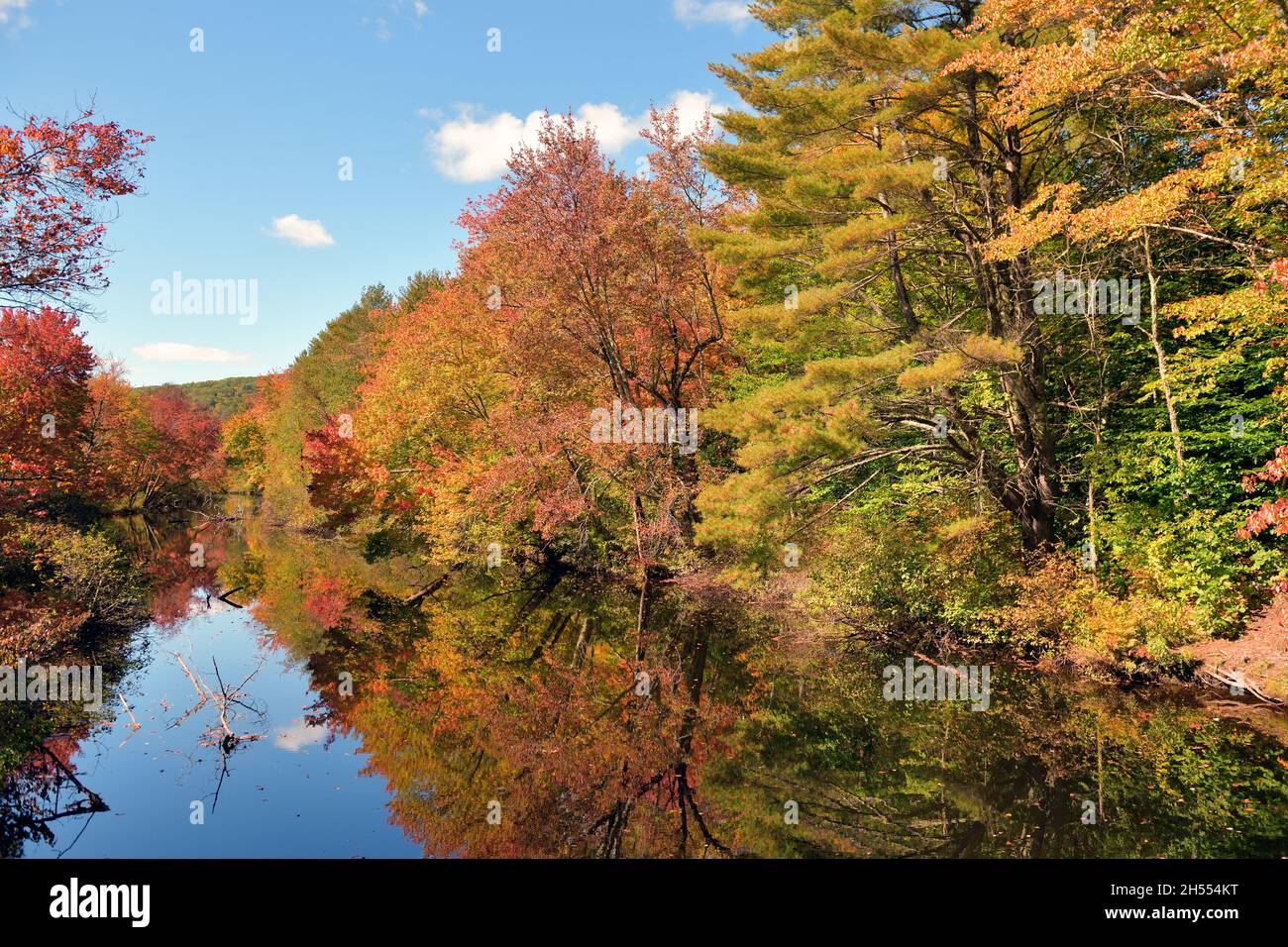 Warner, New Hampshire, USA. Der Warner River spiegelt die Farben des Übergangs vom Sommer zum Herbst in seinen Gewässern wider. Stockfoto