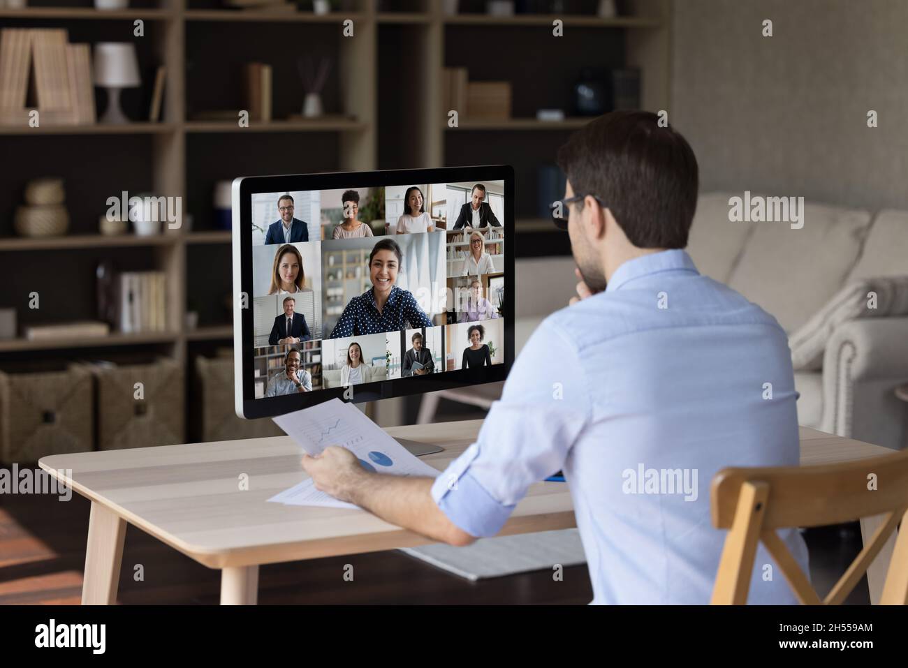 Konzentrierter junger Geschäftsmann, der Verhandlungen mit Videoanruf führt. Stockfoto