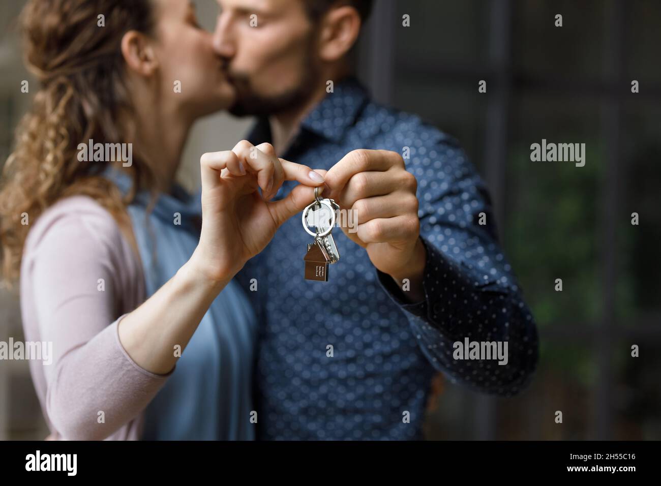 Liebevoll küssen Millennial paar zeigt Schlüssel zur Kamera Stockfoto
