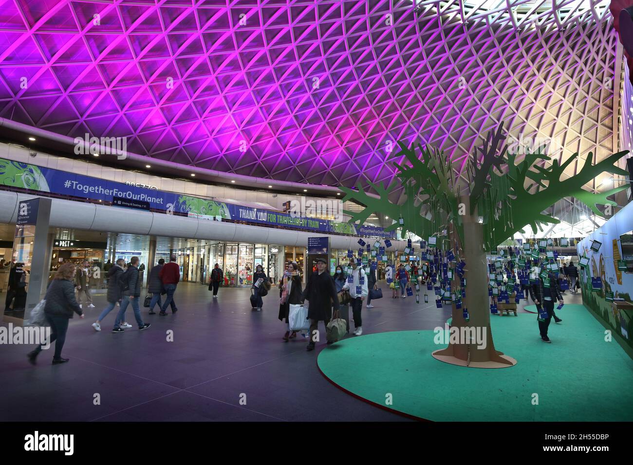 London, Großbritannien. November 2021. Reisende kommen am grünen Hitachi-Stand vorbei, während der Bahnhersteller auf der Hauptkonkursanlage am Bahnhof Kings Cross ein interaktives Erlebnis aufgebaut hat, werden Besucher gebeten, eine Erklärung zu schreiben, wie sie dem Klimawandel helfen und ihn an einen Baum binden werden. Hitachi ist Hauptpartner der COP26. Kredit: SOPA Images Limited/Alamy Live Nachrichten Stockfoto