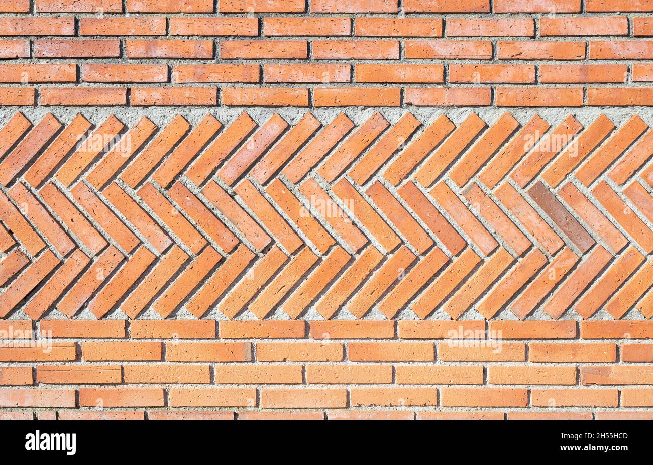 Ein Hintergrund aus roten Ziegeln in verschiedenen Positionen, diagonal und horizontal. Gerade Linien und Fischgrätenmuster. Mauerwerk Fähigkeiten. Stockfoto
