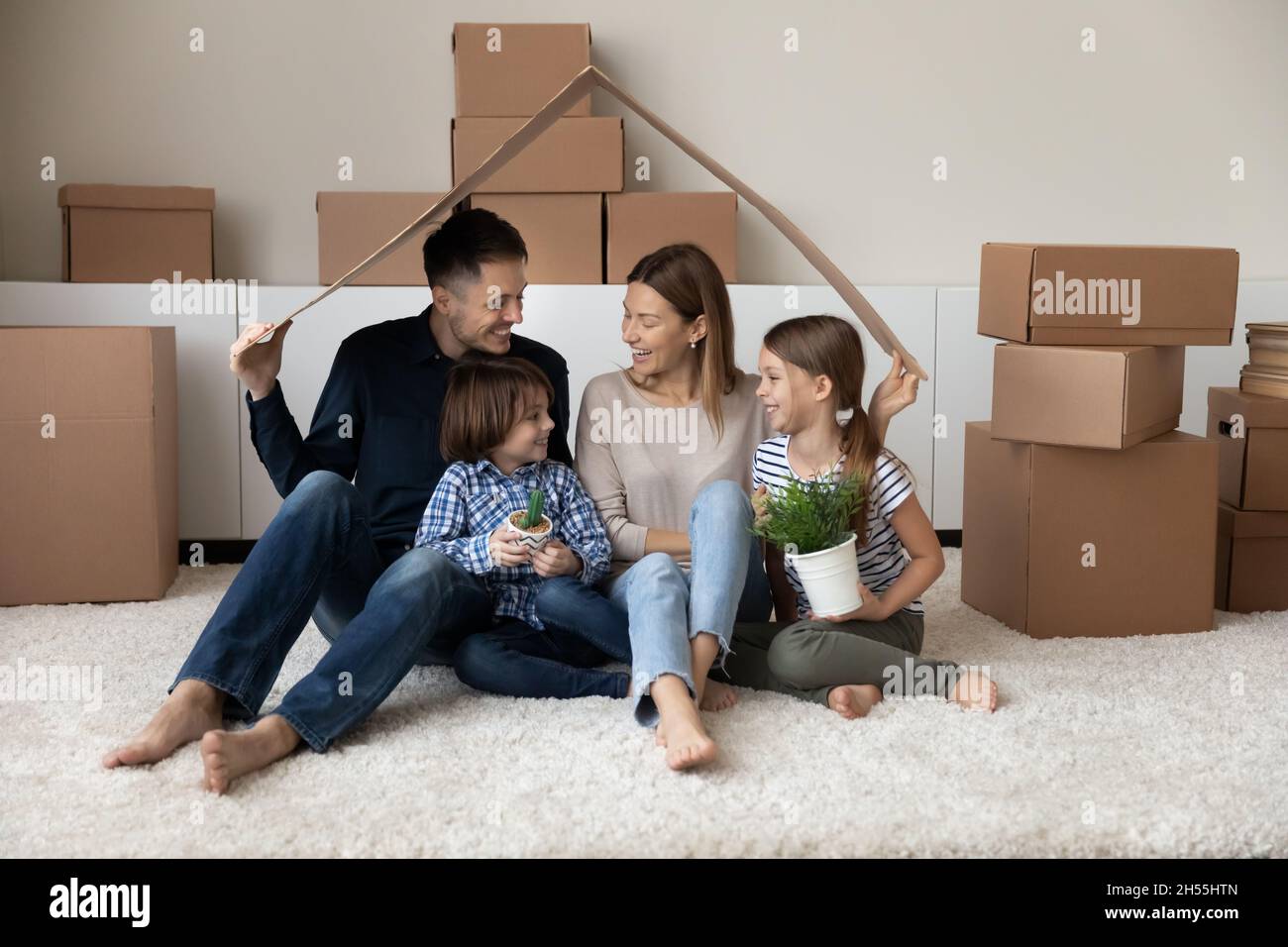 Glückliche Familie, die den Tag in Bewegung genießt und Spaß in neuem Zuhause hat Stockfoto