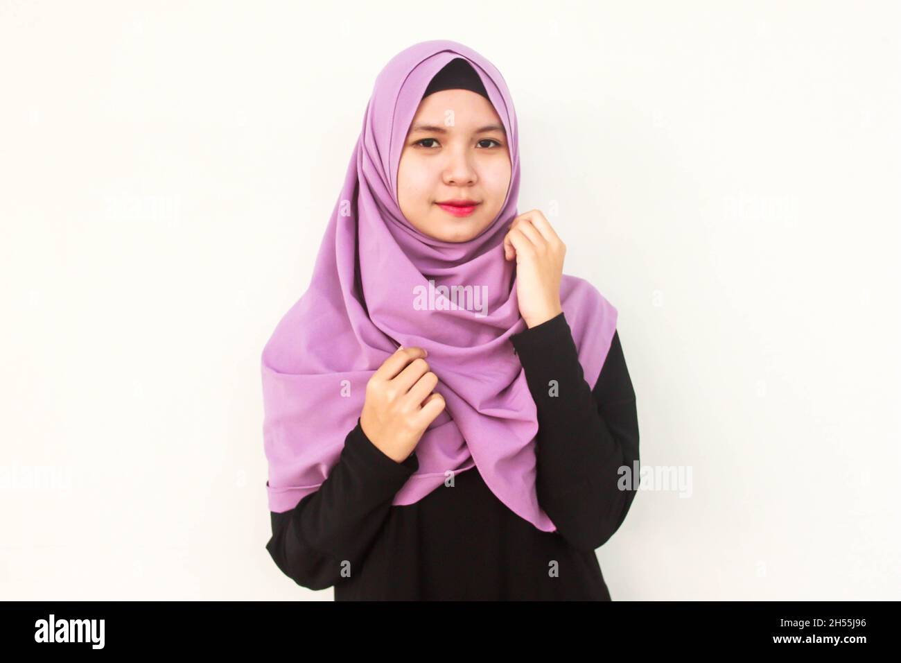 Eine Indonesierin posiert im purpurnen Hijab-Schleier Stockfoto