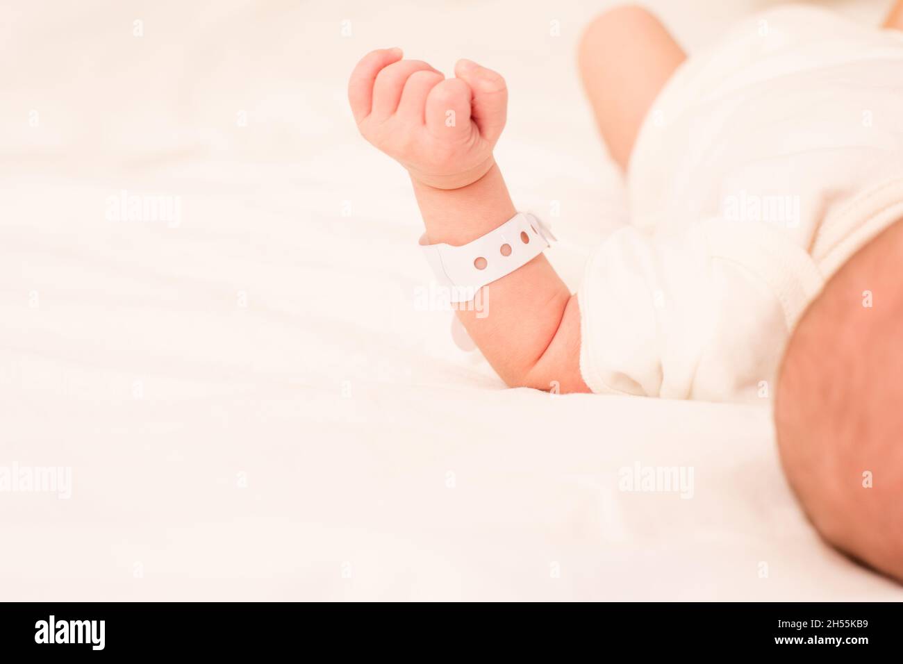Das neugeborene Baby schläft auf dem Bett in der Entbindungsklinik Stockfoto