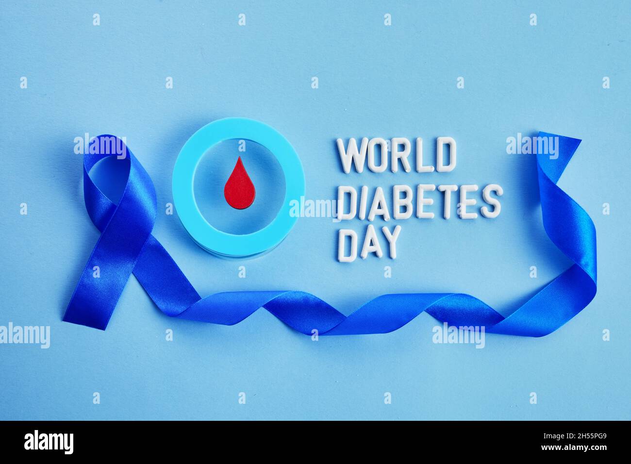 Bewusstsein für den Weltdiabetestag. Blaues Band und Kreis mit Blutstropfen. Stockfoto
