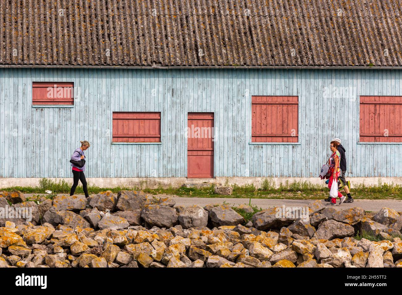 Holzhaus in hellblau gestrichen, rote Türen und Fensterläden. Passanten. Cayeux-sur-Mer, Opalküste, Frankreich Stockfoto