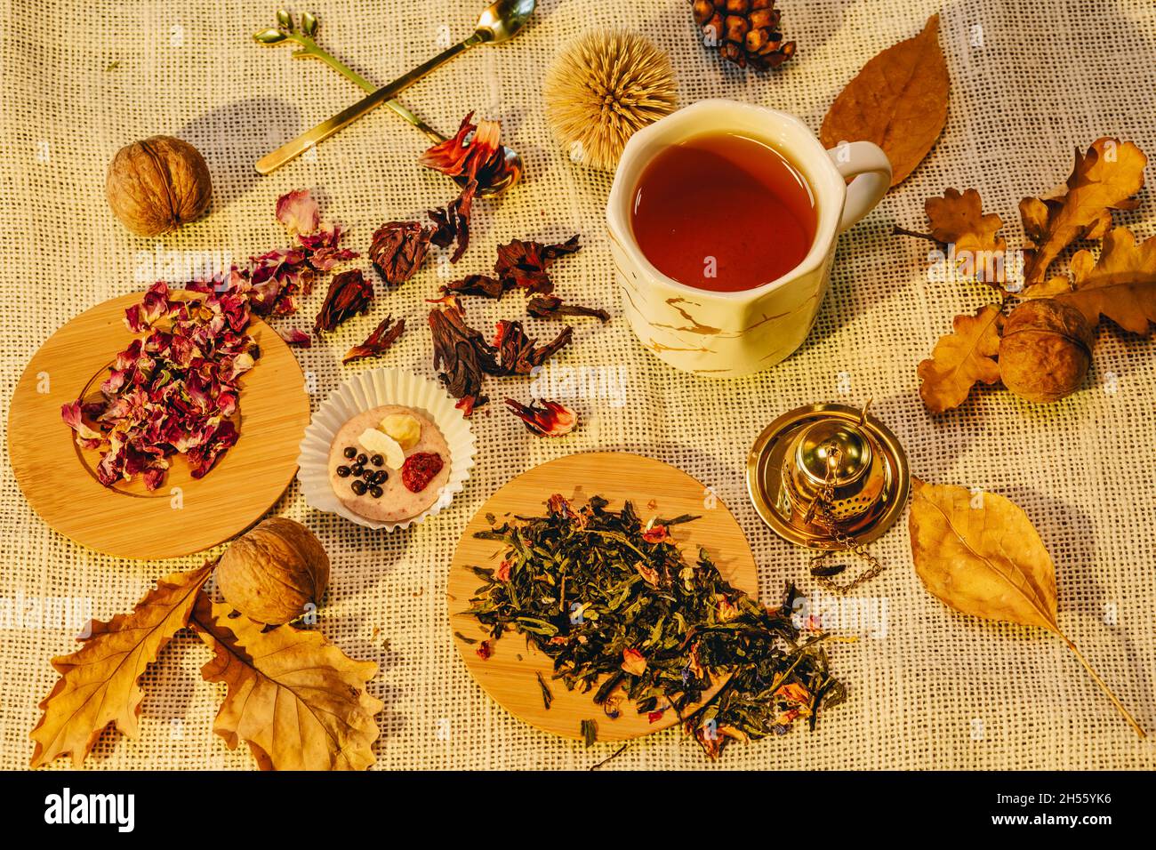 Stillleben im Herbst mit getrockneten Teelaubennüssen und einer Tasse Tee. Warme Herbststimmung mit Herbstblättern Stockfoto