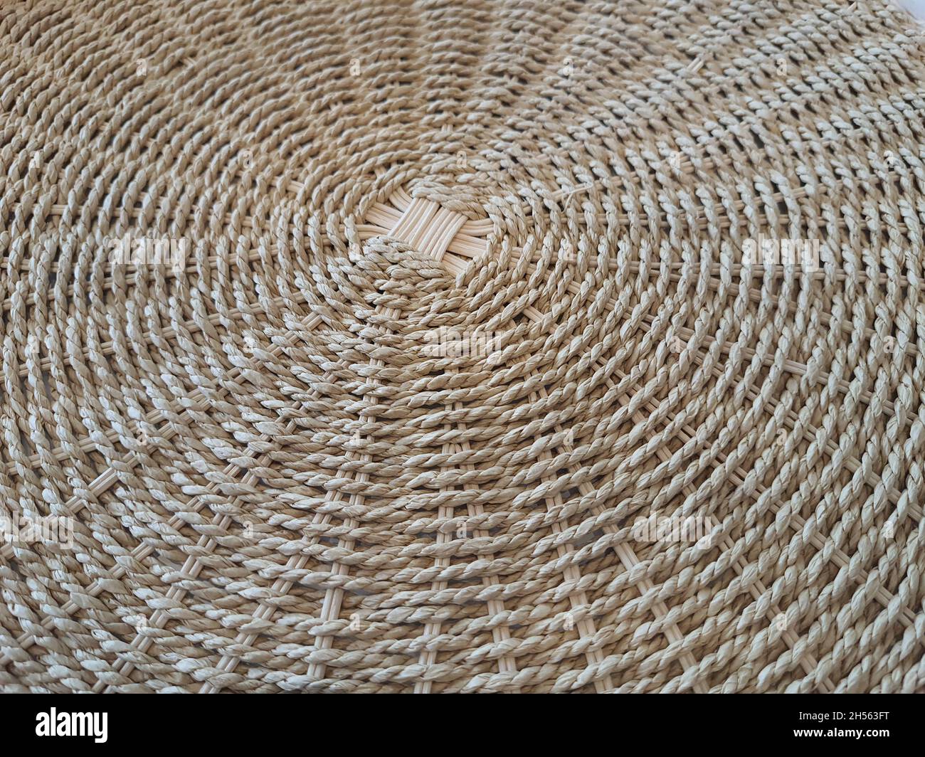 Nahaufnahme auf der Unterseite eines Bambus- und Naturfaserkorbs, Vollbild, Draufsicht. Stockfoto