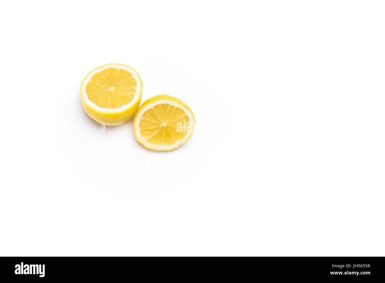 Foto von zwei Hälften gelber Zitronen auf weißem Hintergrund.das Foto hat Platz für Kopien und ist im horizontalen Format aufgenommen. Stockfoto