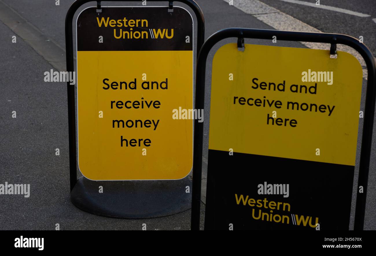 Logo des Geldtransferunternehmens Western Union auf Tafeln am Straßenrand. Stockfoto