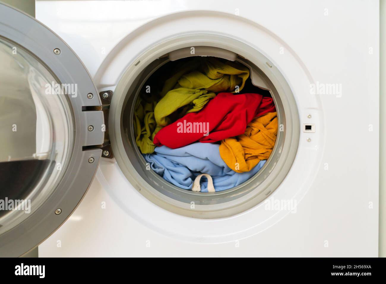 Helle Kleidung in der Waschmaschine. Stockfoto