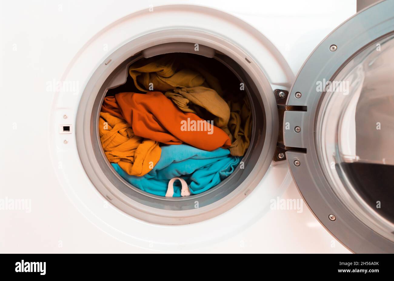 Helle Kleidung in der Waschmaschine. Stockfoto