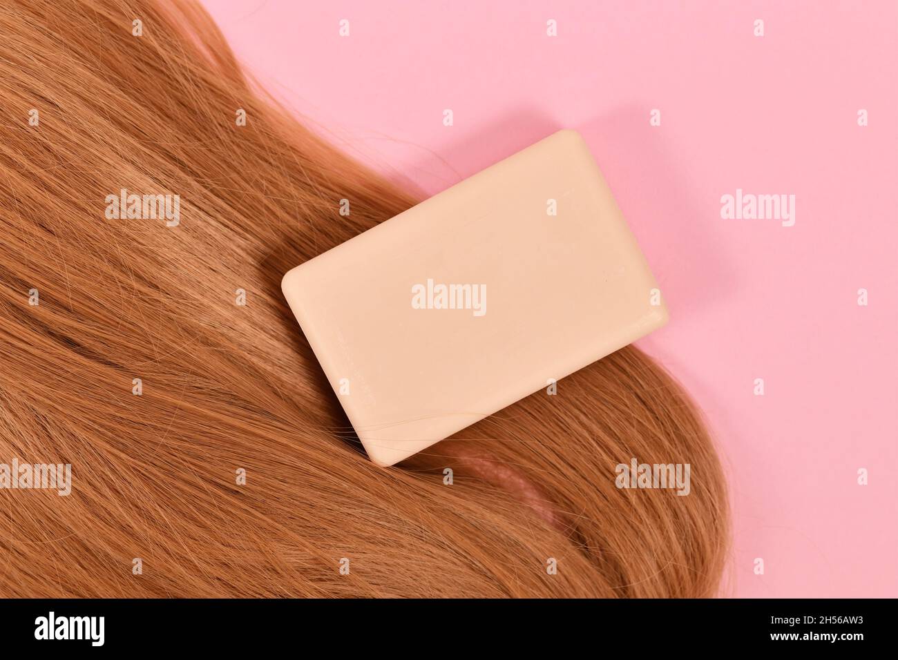 Solide Shampoo-Bar mit gesundem Haar auf rosa Backgorund Stockfoto