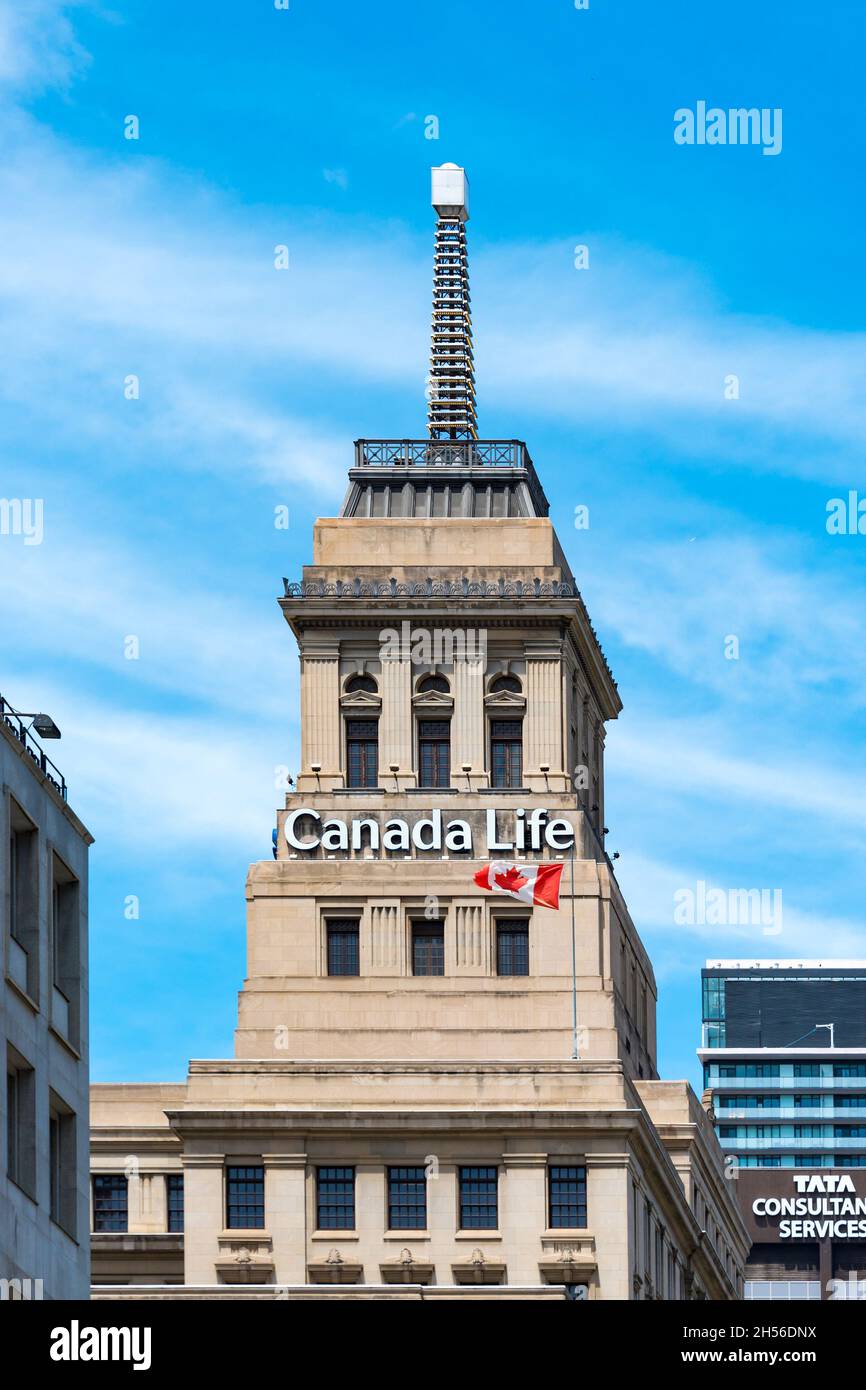 Canada Life Building mit seinem berühmten Wetterfeuer auf der Oberseite. Eine kanadische Flagge fliegt an dem berühmten Ort in Toronto, Kanada. November 6, 2021 Stockfoto