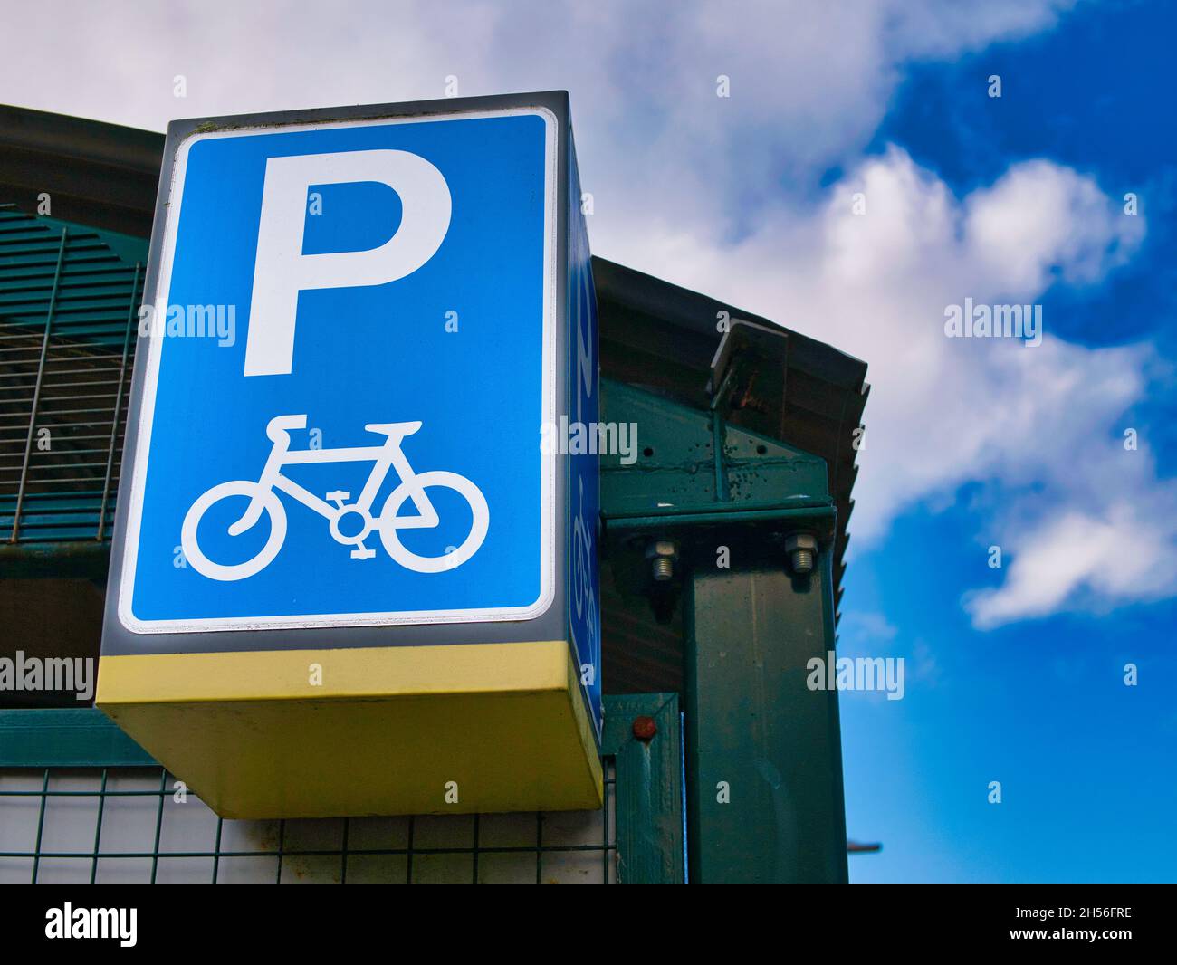 Ein großes blaues Schild mit weißer Grafik markiert eine sichere Fahrradabsperrung an einem lokalen Bahnhof im Merseyrail-Netz in Wirral, Großbritannien Stockfoto