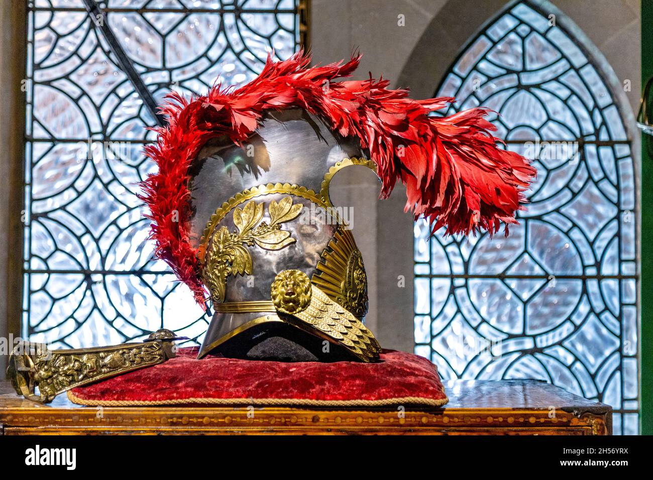 Mittelalterlicher Kavalleriehelm mit goldenen Ornamenten und roten Federn, ausgestellt im Arundel Castle, West Sussex, Großbritannien Stockfoto