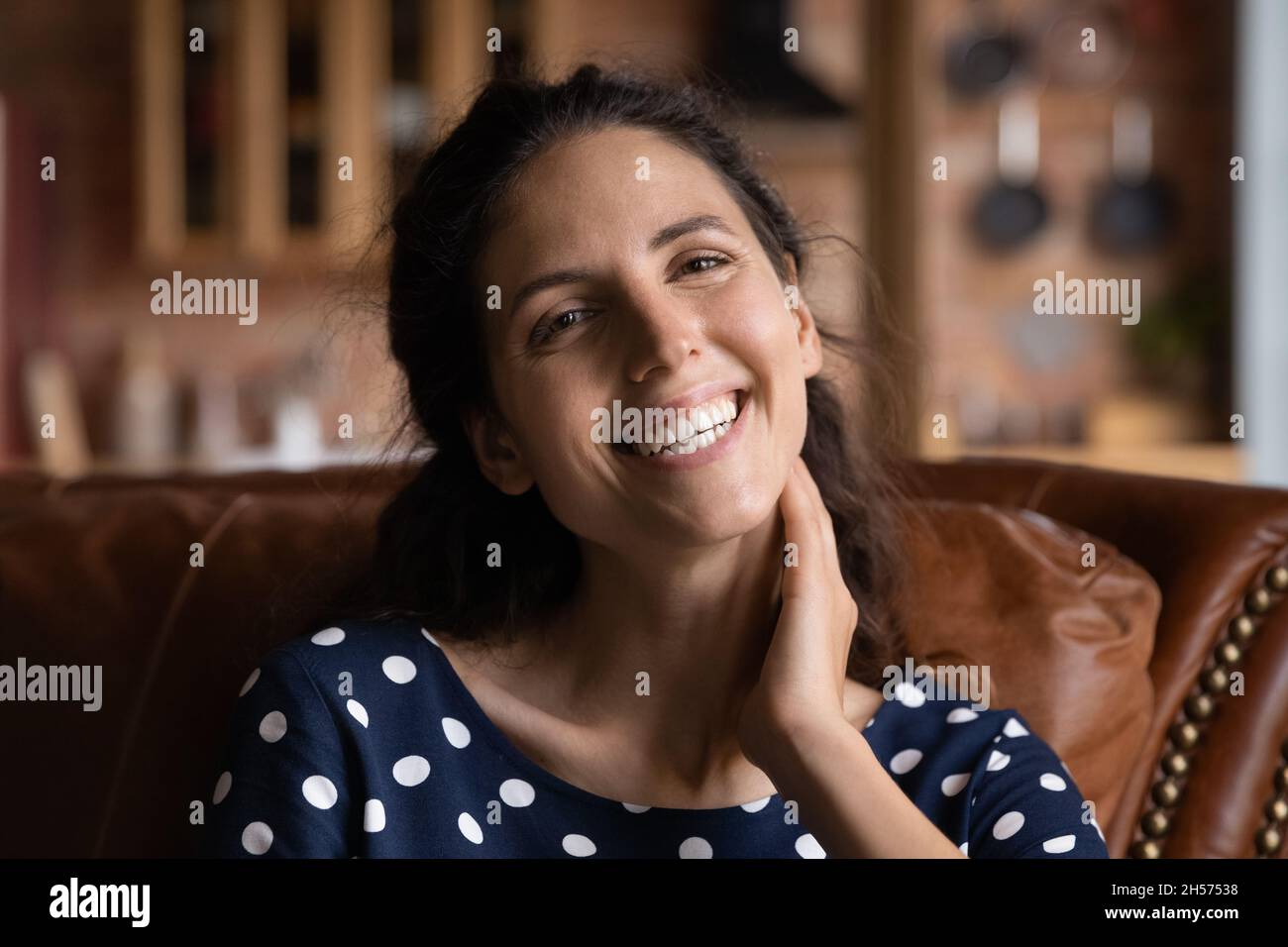 Fröhliche junge Frau, die zu Hause die Kamera ansieht Stockfoto