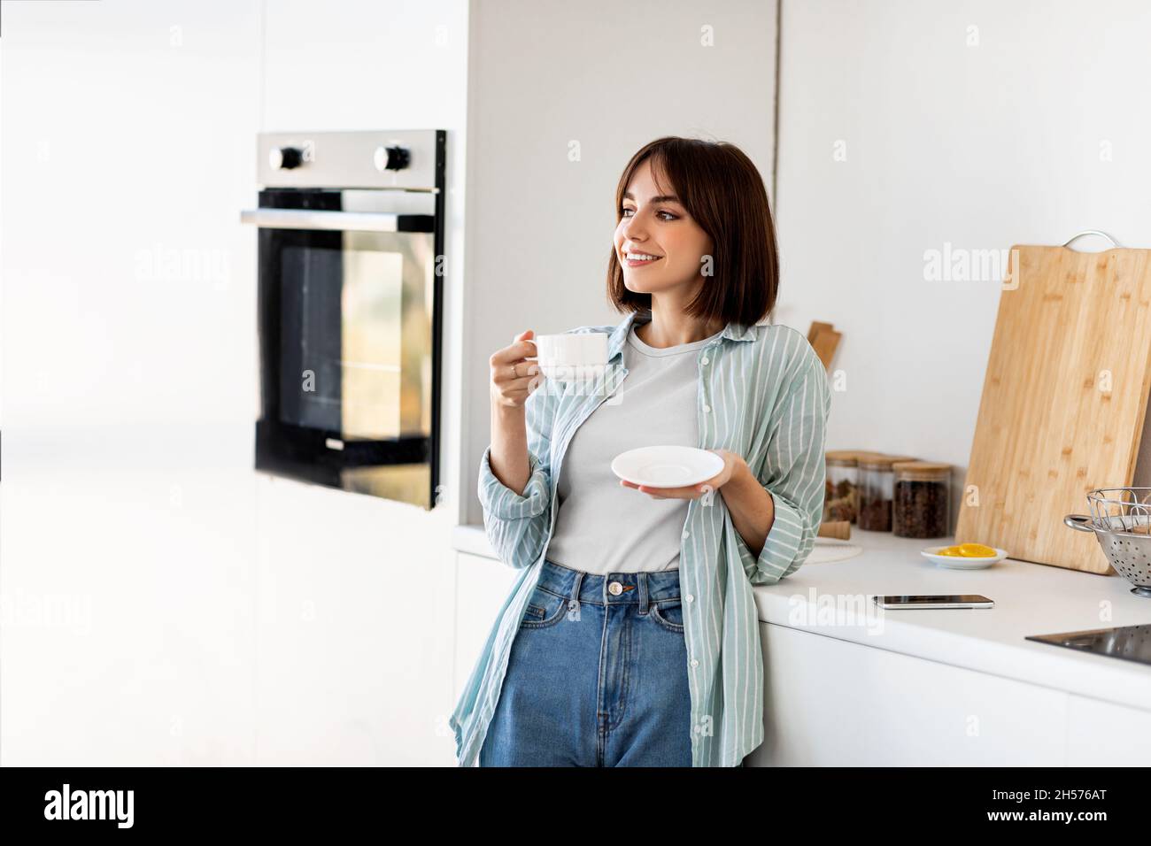 Guten Morgen und leckeren Kaffee, Ruhe und genießen Sie Wochenende. Junge, entspannte kaukasische Dame, die Kaffee trinkt und träumt Stockfoto