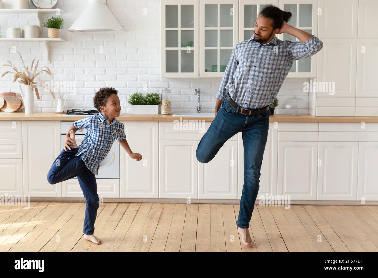 Hübscher afroamerikanischer Vater, der dem kleinen Sohn das Tanzen beibringt Stockfoto