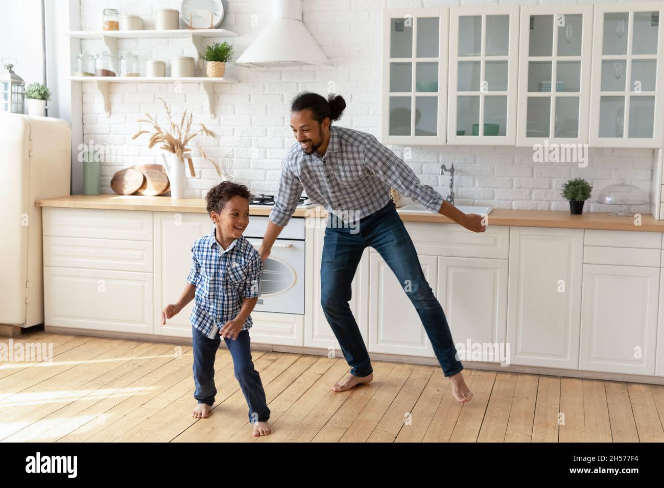 Aufgeregt Vater und kleiner Sohn Junge mit Spaß in der Küche Stockfoto