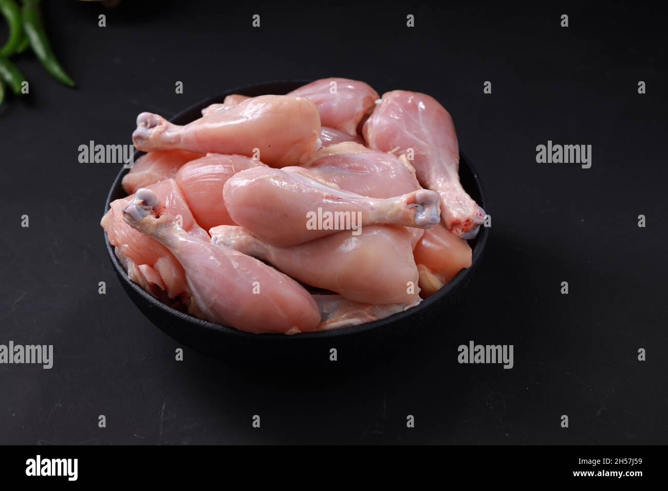 Rohes Huhn biriyani geschnitten ohne Haut auf schwarzem Behälter mit Zutaten in der Nähe platziert Kochen angeordnet. Stockfoto