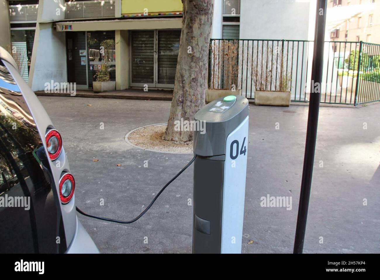 Ladestation für Elektroautos, die ein Auto auf den Straßen von Paris, Frankreich, betankt. Stockfoto