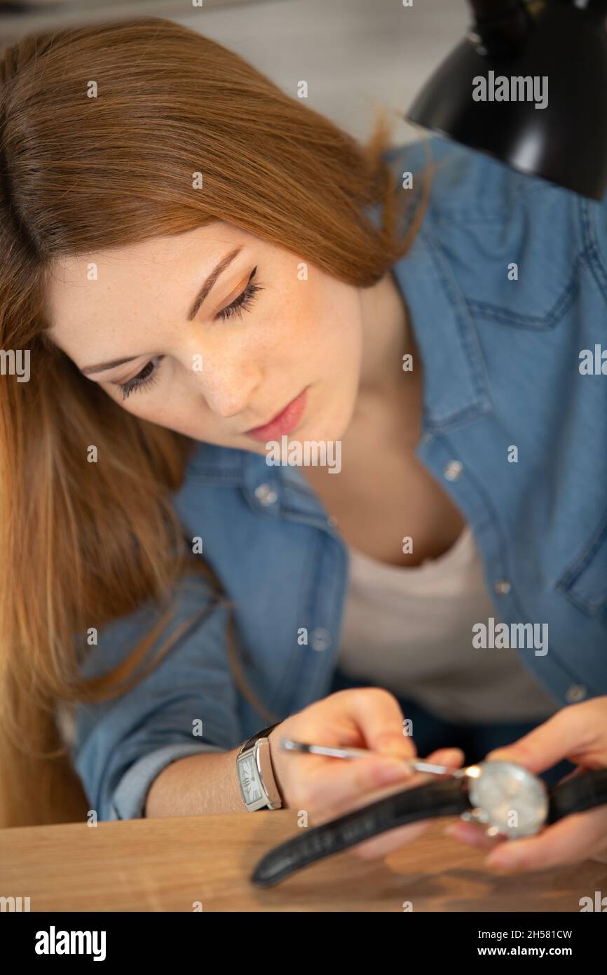 Junge Frau, die ein Uhrenarmband ersetzt Stockfoto