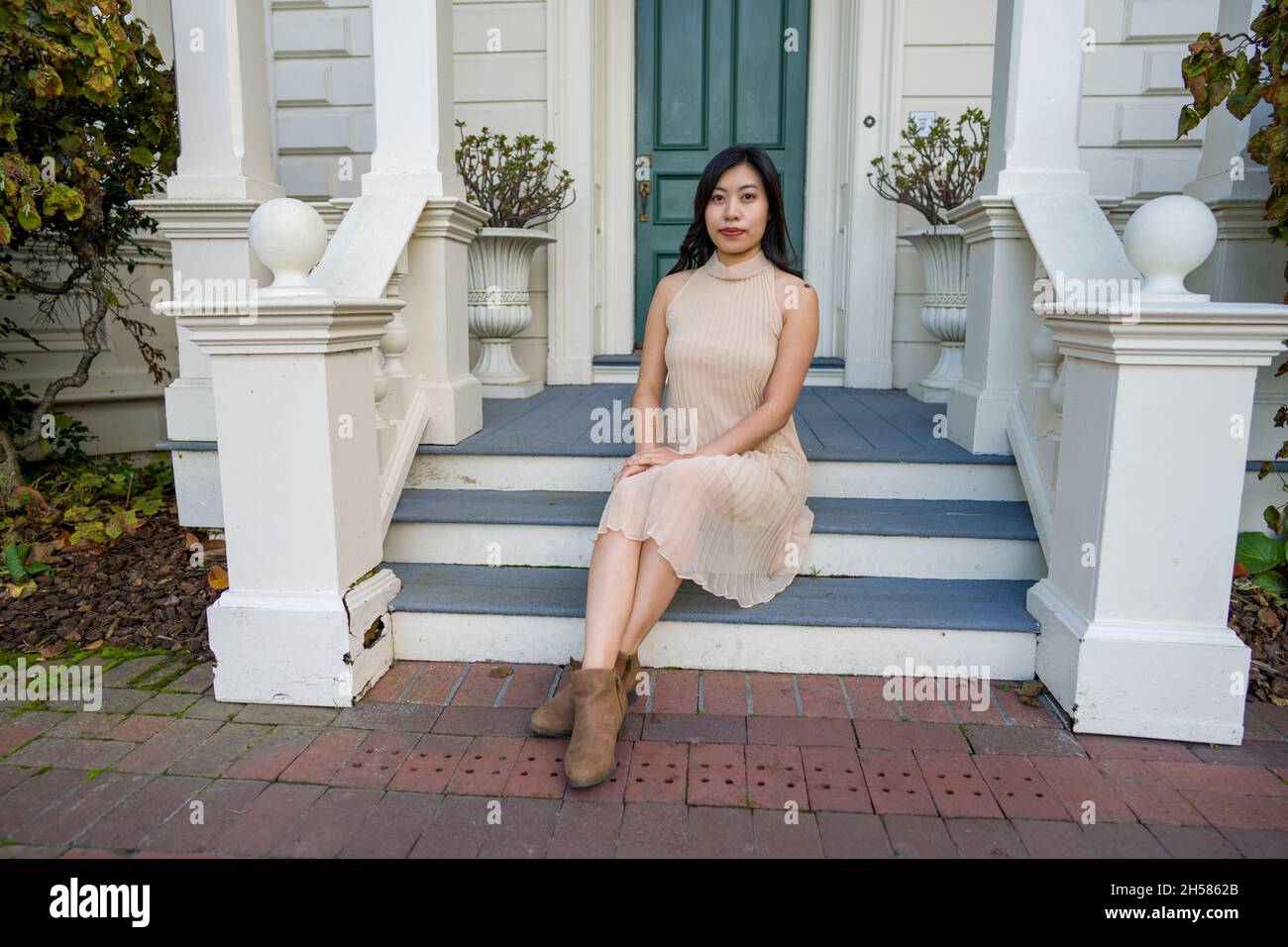 Junge asiatische Frau in einem historischen viktorianischen Haus und Garten Stockfoto