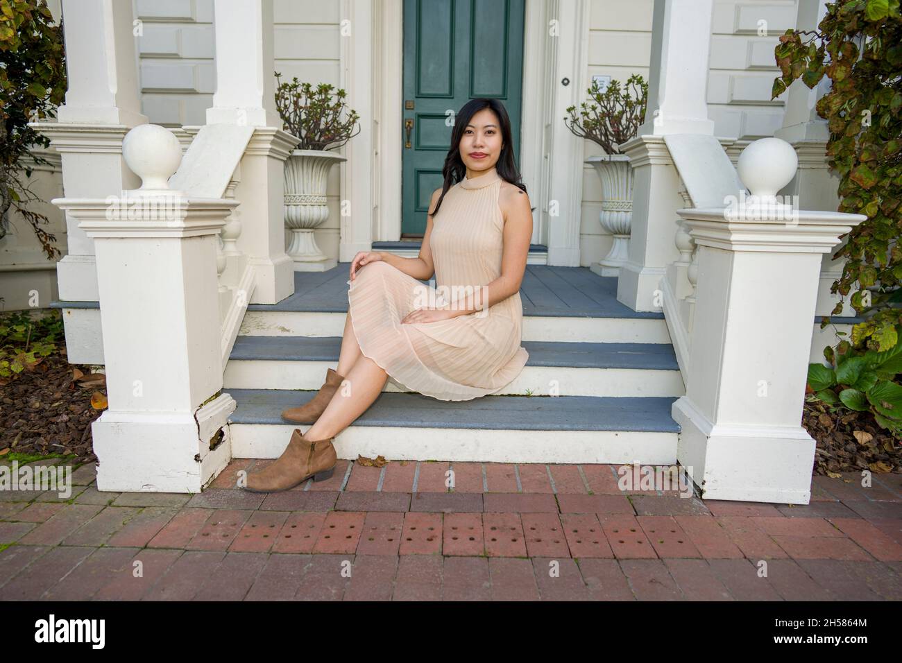 Junge asiatische Frau in einem historischen viktorianischen Haus und Garten Stockfoto