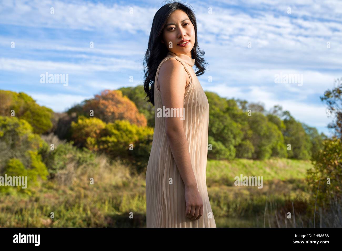 Junge asiatische Frau in einem beigen Kleid zu Fuß in den Sümpfen Stockfoto
