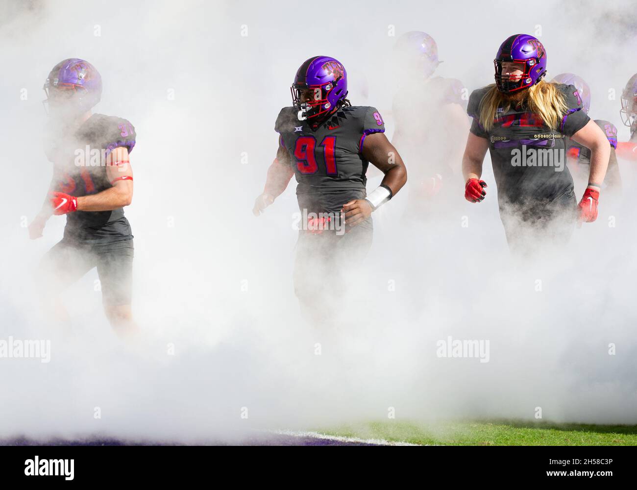 Fort Worth, Texas, USA. November 2021. TCU Horned Frogs Defensive Tackle Patrick Jenkins (91) tritt vor der ersten Hälfte des NCAA Football-Spiels zwischen den TCU Horned Frogs und Baylor Bears im Amon G. Carter Stadium in Fort Worth, Texas, durch den Tunnel durch den Rauch aus. Matthew Lynch/CSM/Alamy Live News Stockfoto