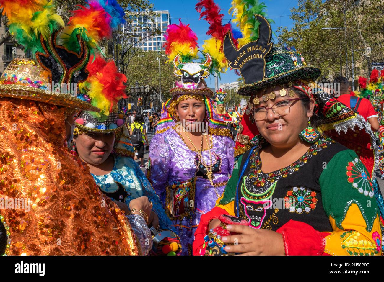 Weibliche Mitglieder einer bolivianischen Tanzgruppe in bunten traditionellen Kostümen. Foto aufgenommen in Barcelona (Spanien) am Nationalfeiertag Spaniens. Stockfoto