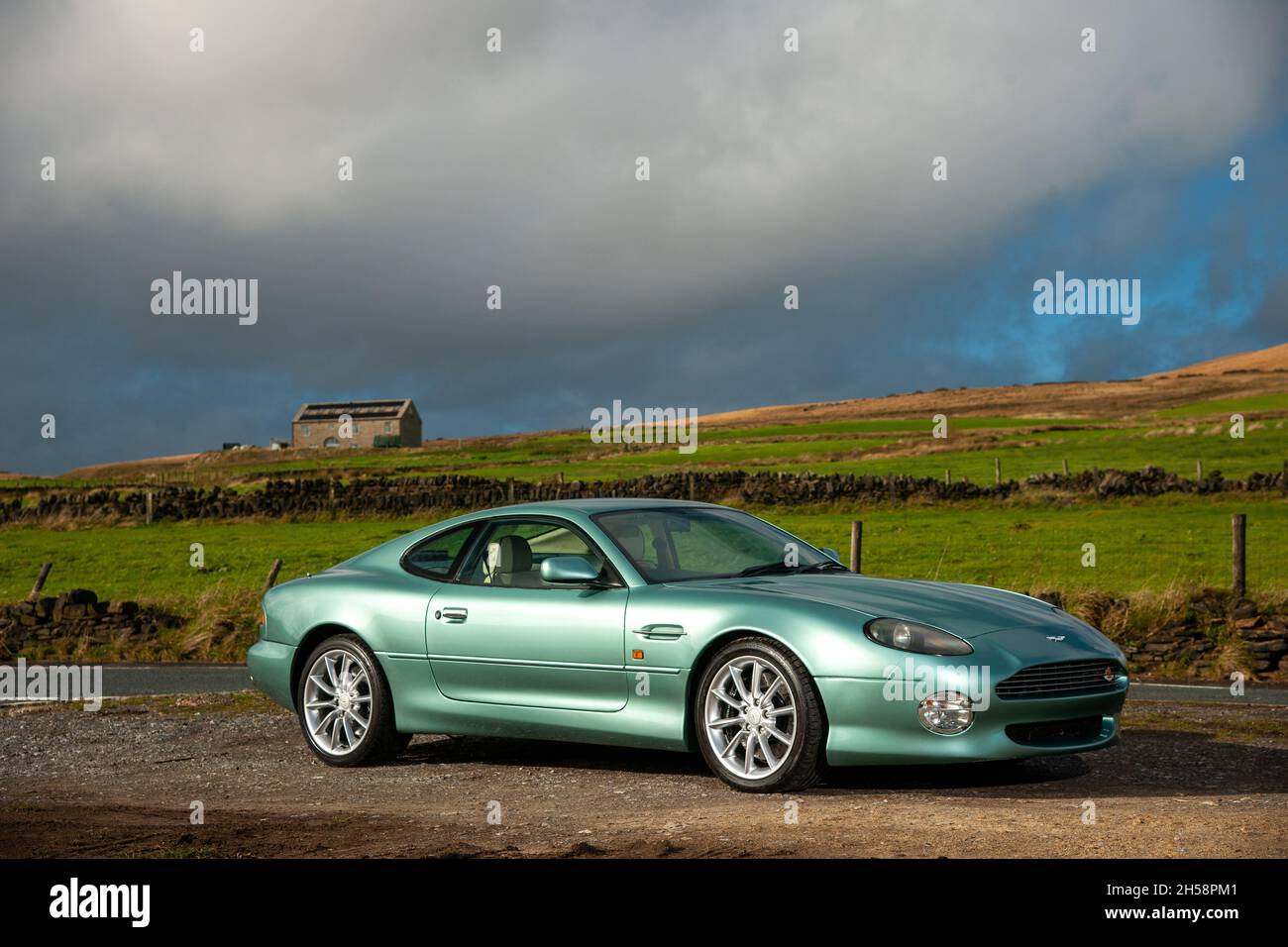 Aston Martin DB7 Vantage V12 parkte auf einer Landstraße unterhalb des Moorlandes im Peak District Stockfoto