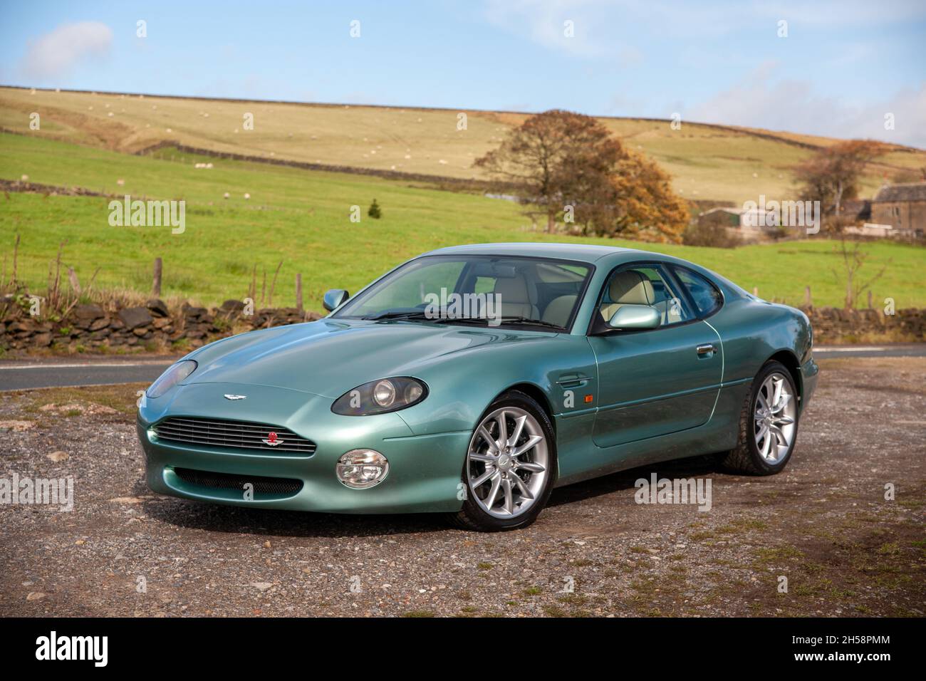 Aston Martin DB7 Vantage V12 parkte auf einer Landstraße unterhalb des Moorlandes im Peak District Stockfoto