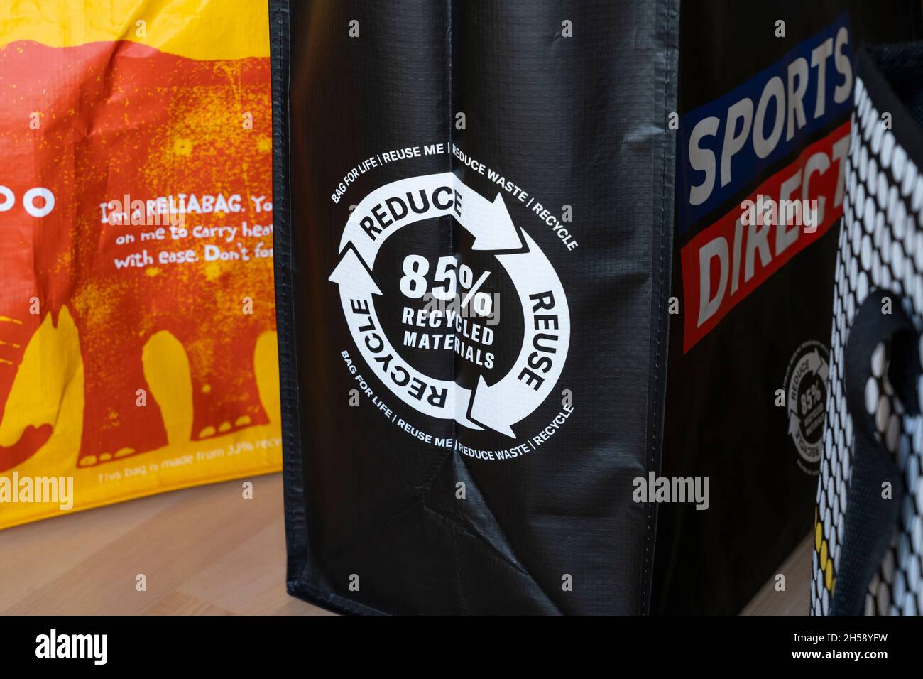 Taschen fürs Leben aus britischen Geschäften. Konzept - Reduzierung der Verwendung von Einweg-Plastiktüten, Reduzierung der Wiederverwendung Recycling, recycelter Kunststoff Stockfoto