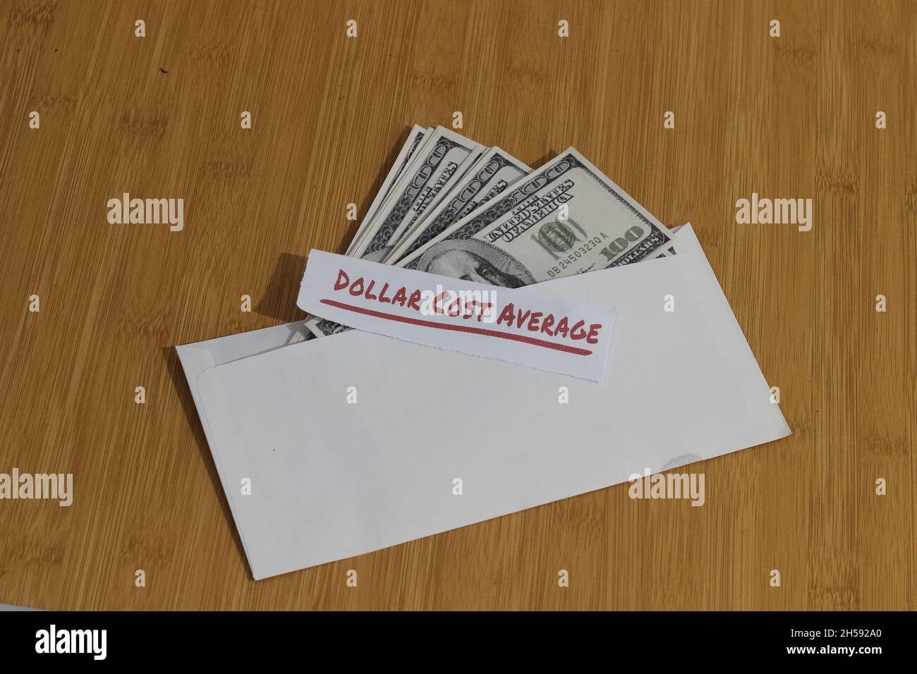 Konzeptfoto, Geldpapier in weißem Umschlag und Text Dollar Cost Average oder DCA Golden Rule Investment Stockfoto