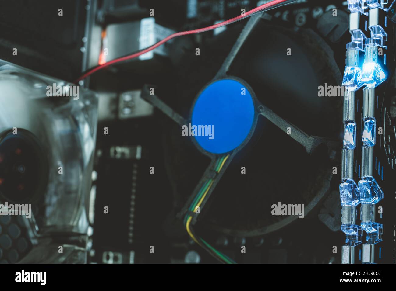 RAM-Speicher auf der Hauptplatine des Computers mit blauem Licht. Im Desktop-PC steckt viel Staub. PC-System. Computerhardware. Elektronischer Chip. PC-RAM und Lüfter Stockfoto